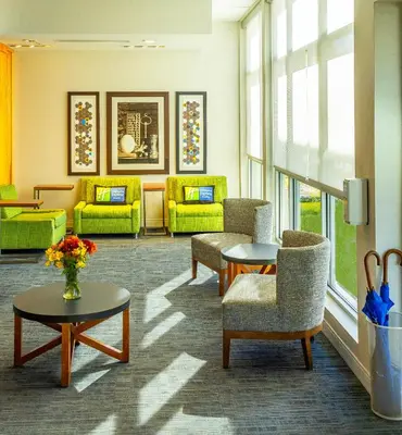 a waiting room with chairs and tables and windows at Holiday Inn Express & Suites Toledo West by IHG in Toledo