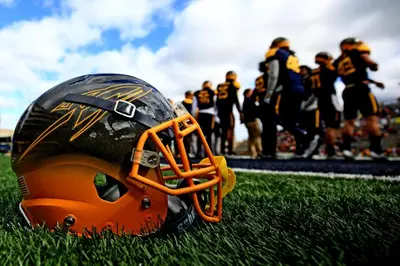 a football helmet on the field with a football team in the background at Holiday Inn Express & Suites Toledo West by IHG in Toledo
