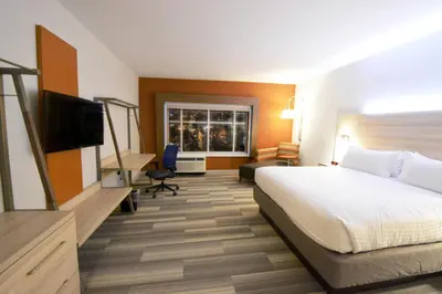 a hotel room with a bed and a flat screen tv at Holiday Inn Express & Suites Toledo West by IHG in Toledo