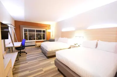 a hotel room with two beds and a desk at Holiday Inn Express & Suites Toledo West by IHG in Toledo