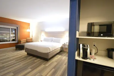 a hotel room with a bed and a flat screen tv at Holiday Inn Express & Suites Toledo West by IHG in Toledo