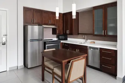 a kitchen with a wooden table and stainless steel appliances at Residence Inn by Marriott Wheeling/St. Clairsville in Saint Clairsville