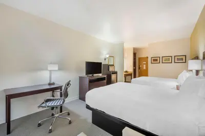 a hotel room with a bed and a desk with a computer at Best Western Celina in Celina