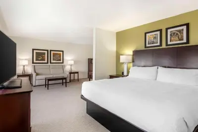a hotel room with a large bed and a chair at Best Western Celina in Celina