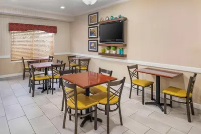 a restaurant with tables and chairs and a flat screen tv at Best Western Celina in Celina