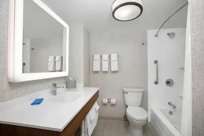 a bathroom with a sink and a toilet and a mirror at Holiday Inn Express Charleston-Civic Center by IHG in Charleston