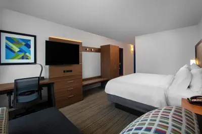 a hotel room with a bed and a desk with a television at Holiday Inn Express Charleston-Civic Center by IHG in Charleston