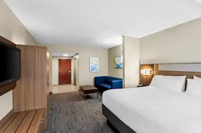 a hotel room with a bed and a flat screen tv at Holiday Inn Express Hotel & Suites Charleston-Southridge by IHG in Charleston
