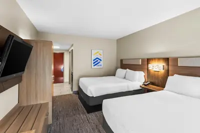 a hotel room with two beds and a flat screen tv at Holiday Inn Express Hotel & Suites Charleston-Southridge by IHG in Charleston
