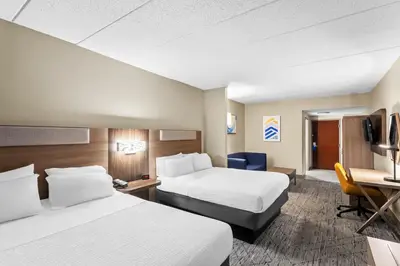 a hotel room with two beds and a desk at Holiday Inn Express Hotel & Suites Charleston-Southridge by IHG in Charleston