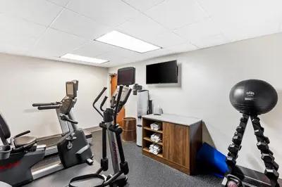 a gym with exercise bikes and a flat screen tv at Holiday Inn Express Hotel & Suites Charleston-Southridge by IHG in Charleston