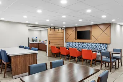 a conference room with tables and chairs and a tv at Holiday Inn Express Hotel & Suites Charleston-Southridge by IHG in Charleston
