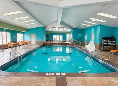 a large swimming pool in a building with blue walls at Holiday Inn Express Hotel & Suites Port Clinton-Catawba Island by IHG in Port Clinton