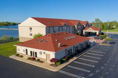 a building with a red roof with a parking lot at Holiday Inn Express Hotel & Suites Port Clinton-Catawba Island by IHG in Port Clinton