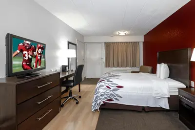 a hotel room with a bed and a flat screen tv at Red Roof Inn Cleveland - Medina in Medina