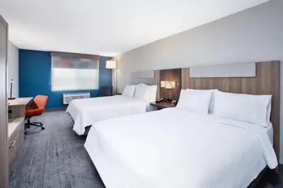 a hotel room with two beds and a desk at Holiday Inn Express Hotel & Suites Defiance by IHG in Defiance