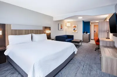 a hotel room with a large bed and a television at Holiday Inn Express Hotel & Suites Defiance by IHG in Defiance