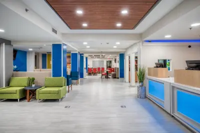 a lobby of a hospital with chairs and tables at Holiday Inn Express Hotel & Suites Greenville by IHG in Greenville