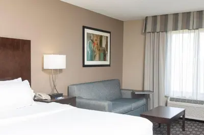 a hotel room with a bed and a chair at Holiday Inn Express Gas City by IHG in Gas City