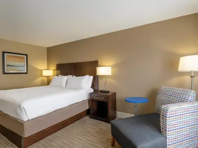 a hotel room with a bed and a chair at Holiday Inn Express Gas City by IHG in Gas City