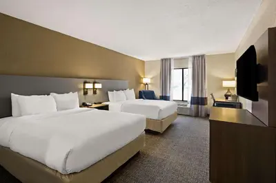 a hotel room with two beds and a television at Comfort Inn Huntington Near University in Huntington