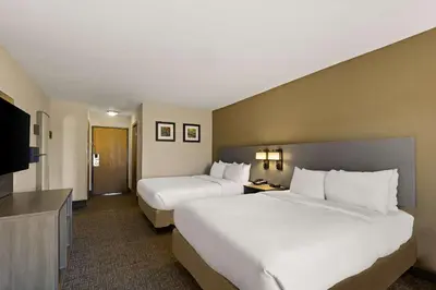 a hotel room with two beds and a flat screen tv at Comfort Inn Huntington Near University in Huntington