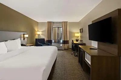 a hotel room with a bed and a flat screen tv at Comfort Inn Huntington Near University in Huntington