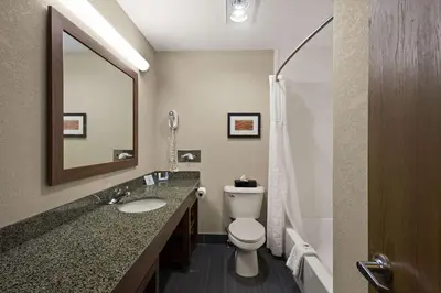 a bathroom with a toilet and a sink and a mirror at Comfort Inn Huntington Near University in Huntington