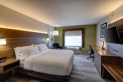 a hotel room with a bed and a flat screen tv at Holiday Inn Express & Suites Shelbyville Indianapolis by IHG in Shelbyville