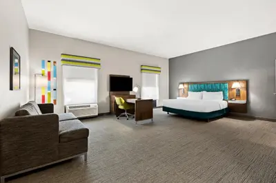 a large hotel room with a bed and a desk at Hampton Inn & Suites Canton in North Canton