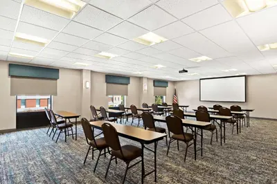 a conference room with tables and chairs and a screen at Hampton Inn & Suites Canton in North Canton