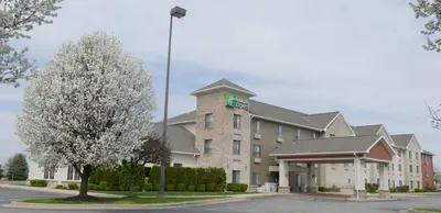 a hotel building with a green sign on it at Holiday Inn Express Greensburg by IHG in Greensburg