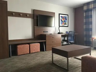a hotel room with a desk and a flat screen tv at Holiday Inn Express Greensburg by IHG in Greensburg