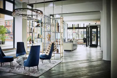 a lobby with blue chairs and a chandelier at Hotel Covington Cincinnati Riverfront in Covington