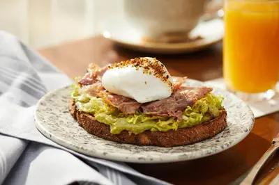a sandwich on a plate with egg and bacon at Hotel Covington Cincinnati Riverfront in Covington
