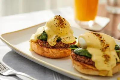 a plate with two eggs on top of a sandwich at Hotel Covington Cincinnati Riverfront in Covington