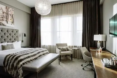 a bedroom with a bed and a desk and a chair at Hotel Covington Cincinnati Riverfront in Covington