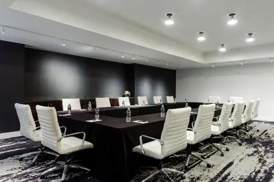 a conference room with a long table and white chairs at Hotel Covington Cincinnati Riverfront in Covington
