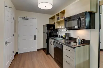 a kitchen with a sink and a microwave at Candlewood Suites Lexington by IHG in Lexington