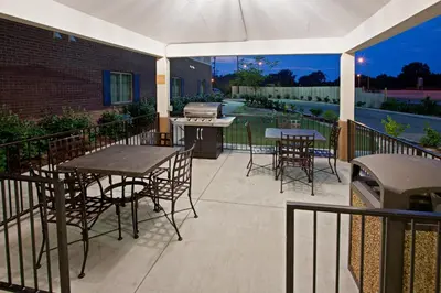 a patio with tables and chairs and a grill at Candlewood Suites Lexington by IHG in Lexington