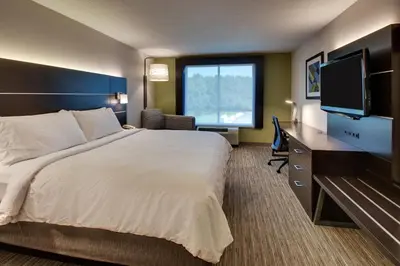 a hotel room with a bed and a flat screen tv at Holiday Inn Express Georgetown by IHG in Georgetown