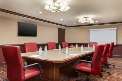 a conference room with a large table and red chairs at DoubleTree by Hilton Cincinnati Airport in Hebron
