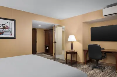 a hotel room with a bed and a desk and a tv at DoubleTree by Hilton Cincinnati Airport in Hebron