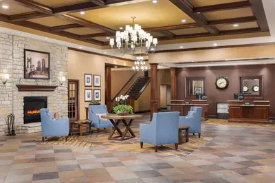 a lobby with a table and chairs and a fireplace at DoubleTree by Hilton Cincinnati Airport in Hebron