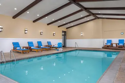 a swimming pool with blue chairs and a table at DoubleTree by Hilton Cincinnati Airport in Hebron