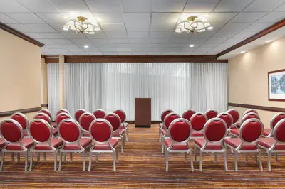 a conference room with red chairs and a podium at DoubleTree by Hilton Cincinnati Airport in Hebron