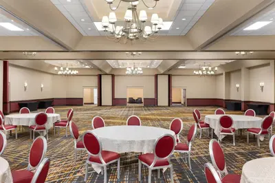 a conference room with white tables and red chairs at DoubleTree by Hilton Cincinnati Airport in Hebron