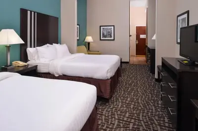 a hotel room with two beds and a flat screen tv at Holiday Inn Express Hotel & Suites Youngstown - North Lima/Boardman by IHG in North Lima