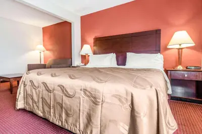 a hotel room with a large bed with red walls at Quality Inn & Suites Lawrenceburg in Lawrenceburg