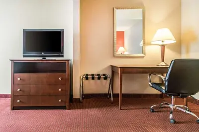 a hotel room with a desk and a television and a chair at Quality Inn & Suites Lawrenceburg in Lawrenceburg